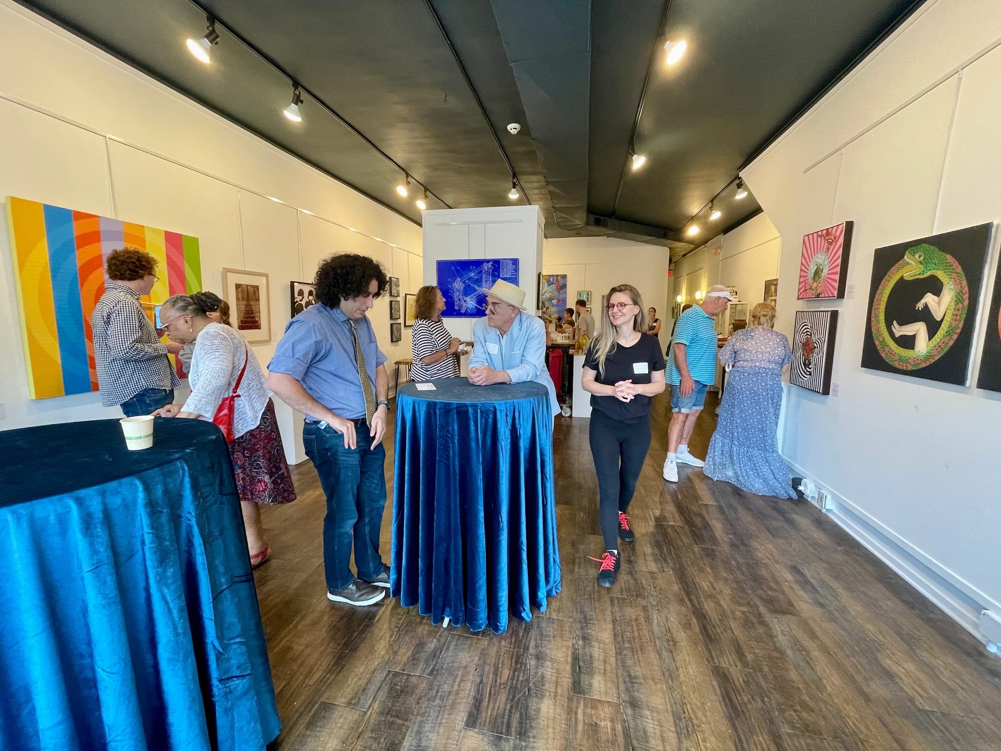 Smiling people browse an art gallery.